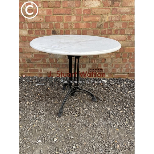 288 - A circular iron based bistro style table with white marble top