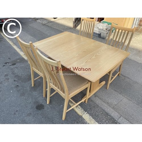 295 - A modern ercol light elm dining table with four chairs