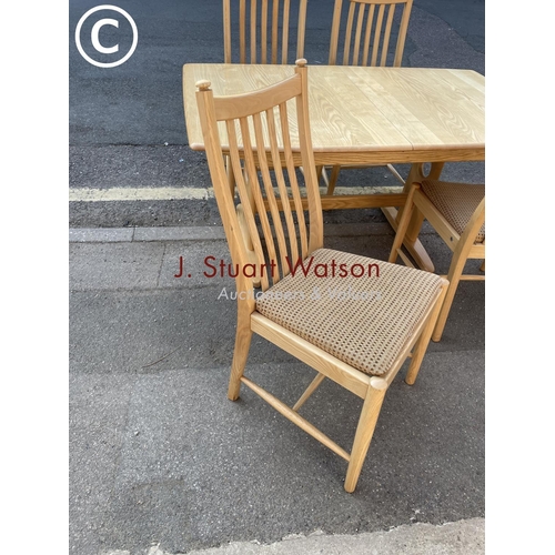 295 - A modern ercol light elm dining table with four chairs