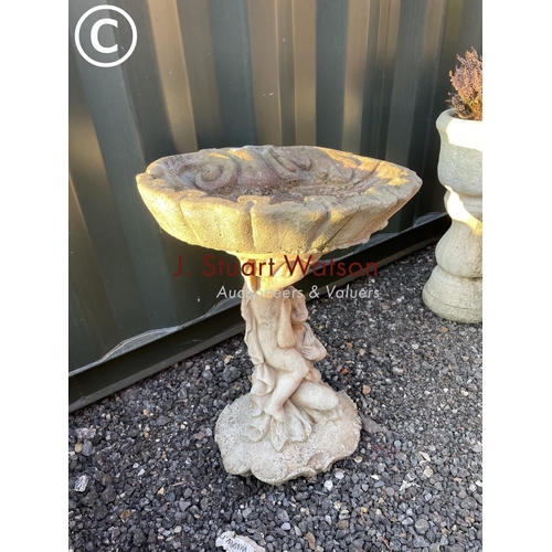 345 - A oyster shell concrete bird bath decprated with cherubs to column base