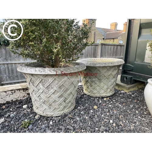 362 - A pair of large cast concrete circular planters decorated with lattice pattern one plamted with topi... 