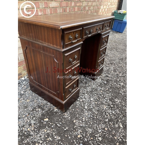 50 - A small reproduction mahogany twin pedestal desk with brown leather top