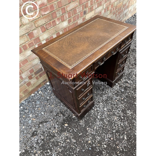 50 - A small reproduction mahogany twin pedestal desk with brown leather top