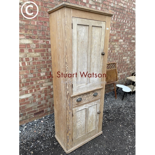 84 - An antique pine larder cupboard with two cupboard doors and a single drawer fitted with shelves to t... 