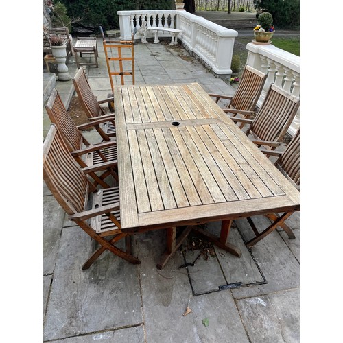 347 - A very large extending hardwood garden table together with a compelte set of 10 folding hardwood car... 