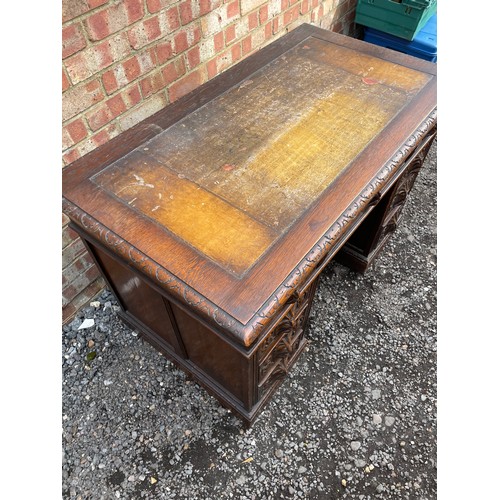 51 - A carved oak kneehole desk 122x70 x77