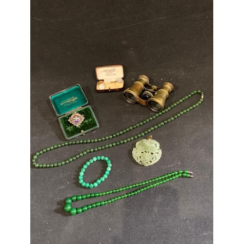 981 - Two jade bead necklaces, bangle and pendant, binoculars, cuff link and and badge