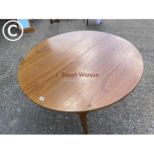 15 - A circular teak extending dining table