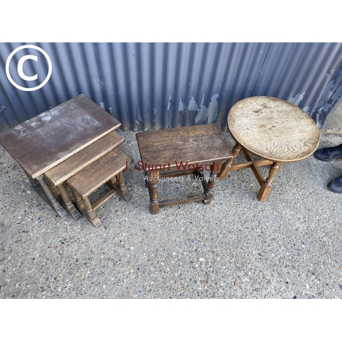 30 - An oak joint stool together with a nest of three tables and a circular occasional table