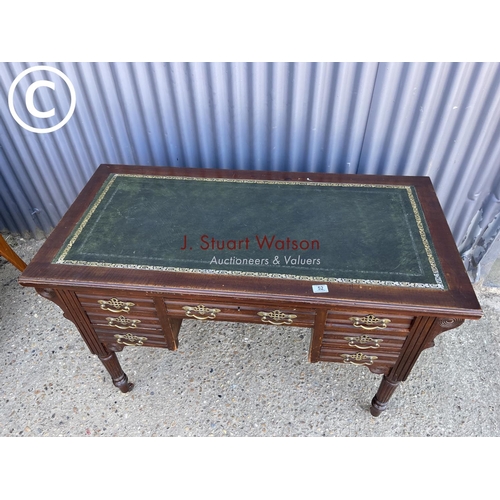 52 - An Edwardian kneehole writing desk with green leather top