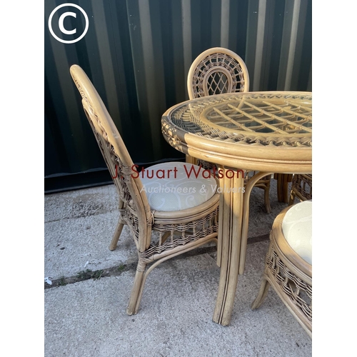 357 - Circular bamboo effect circular dining table with drop in glass top together with four matching chai... 