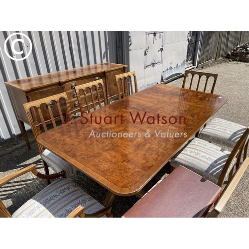 13 - A reproduction walnut dining suite consisting  of a extending table and 8 chairs together with match... 