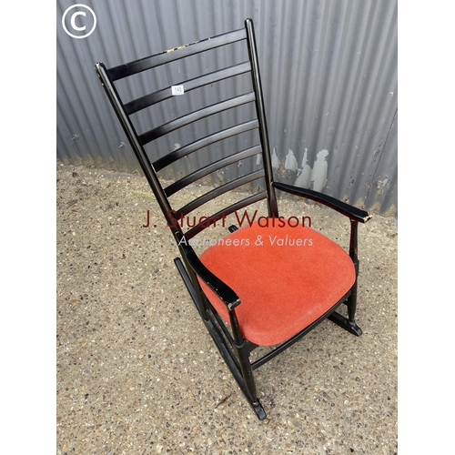 145 - A mid century black painted rocker chair