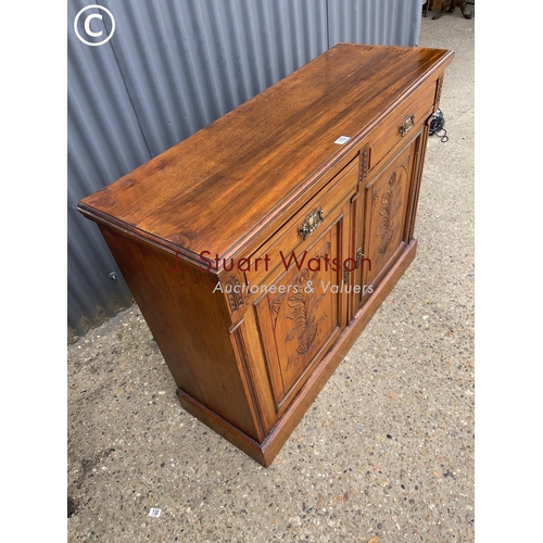 152 - An Edwardian mahogany sideboard having two drawers over two carved cupboard doors