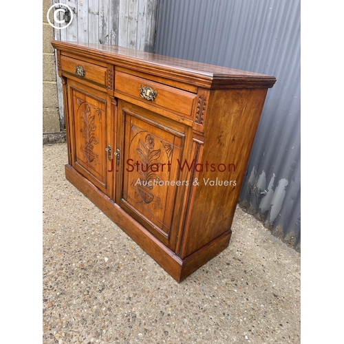 152 - An Edwardian mahogany sideboard having two drawers over two carved cupboard doors