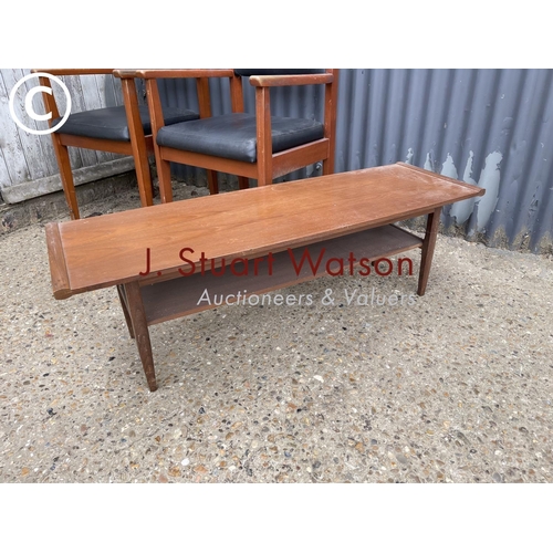 176 - A mid century teak coffee table together with a pair of teak carver chairs