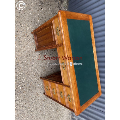 238 - An Edwardian kneehole desk with a green leather top