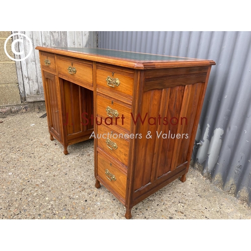 238 - An Edwardian kneehole desk with a green leather top