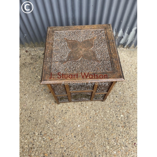 239 - An ornate brass inlaid table on folding base