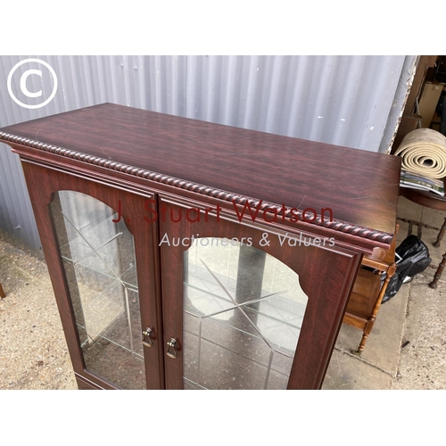 25 - A modern mahogny effect display cabinet with mirror glass interior