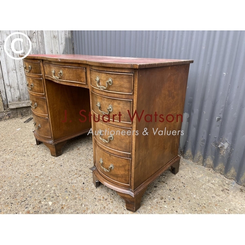 276 - A reproduction mahogany kneehole desk with a red leather top