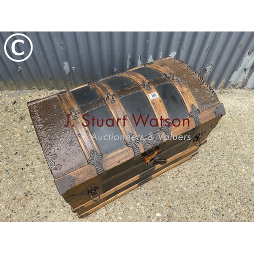 280 - An antique iron and wooden bound domed top trunk decorated to the interior 77x50 x60