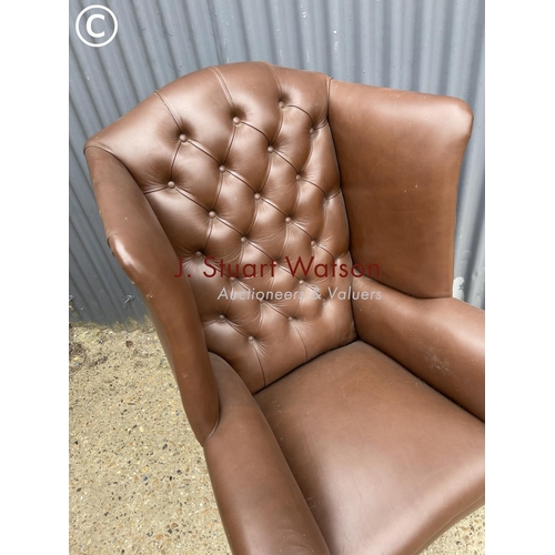 297 - A brown leather chesterfield wing back armchair