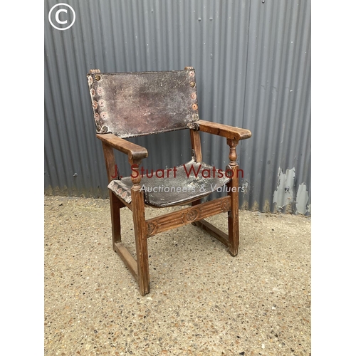 310 - A antique elm framed throne chair with leather seat and brass stud work