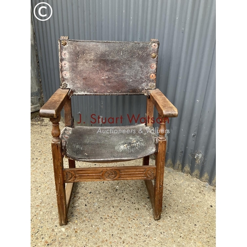 310 - A antique elm framed throne chair with leather seat and brass stud work