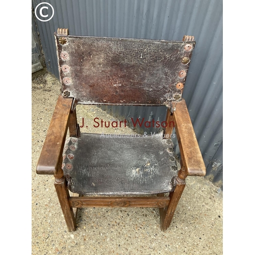 310 - A antique elm framed throne chair with leather seat and brass stud work