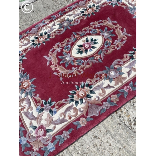 35 - A pink pattern chinese rug together with a circular green pattern rug