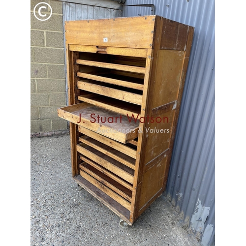 36 - An original vintage bakers 'bun cabinet' tambour front enclosing pine bun drawers. On large castors ... 