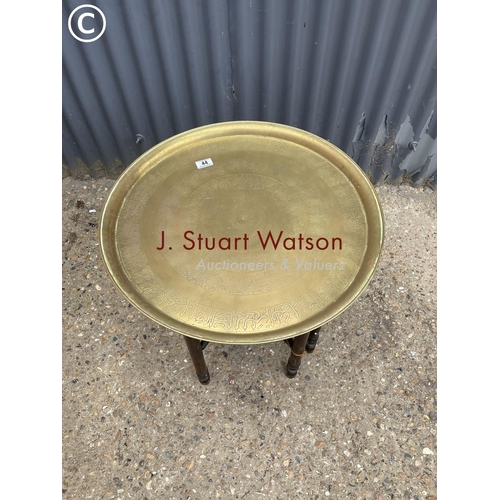 44 - A brass tray top table on folding base