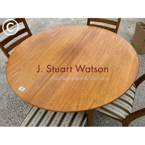 94 - A circular teak table together with four nathan dining chairs