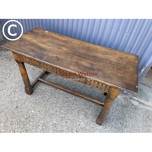 246 - An antique oak stretcher table with drawer