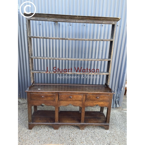 289 - An antique oak three drawer dresser base with later farmhouse style pine plate rack top 154cm wide