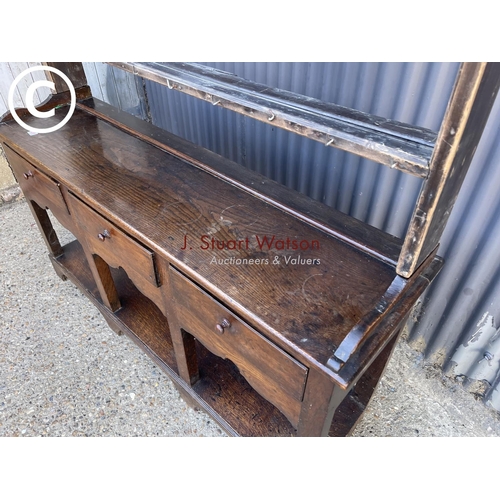 289 - An antique oak three drawer dresser base with later farmhouse style pine plate rack top 154cm wide
