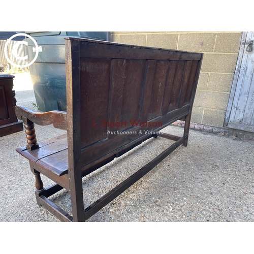 296 - An early oak settle bench seat with carved panel back 156cm wide