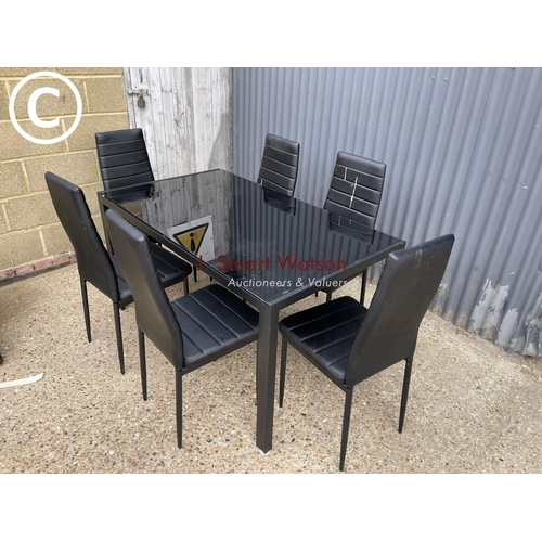 36 - A metal framed dining table with glass top together with six chairs