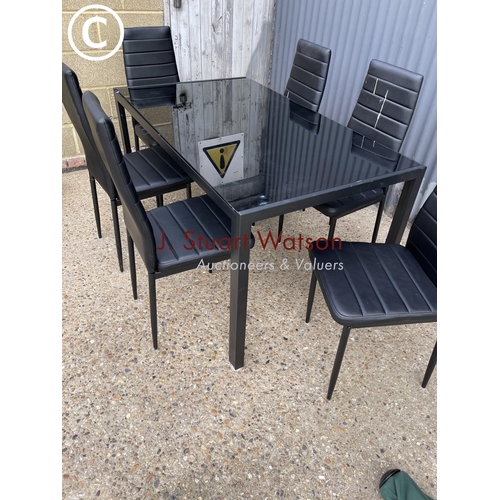 36 - A metal framed dining table with glass top together with six chairs