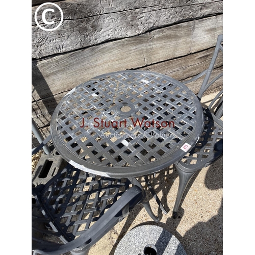 473 - A small circular aluminium garden table and two chairs together with granite parasol stand