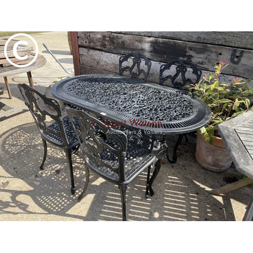 475 - A black painted ornate aluminium garden table with four matching chairs