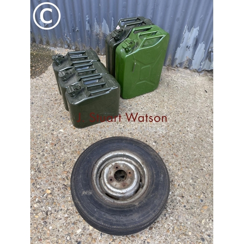 64 - Five assorted Jerry cans and a motorcycle wheel and tyre