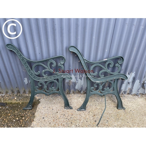 65 - A pair of green iron bench ends