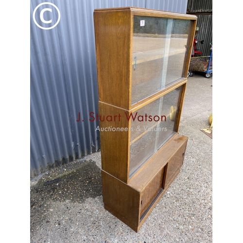 78 - An early 20th century oak three section bookcase with sliding doors