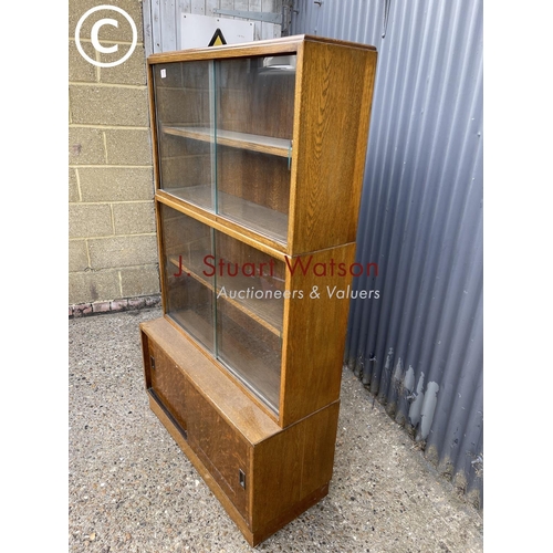 78 - An early 20th century oak three section bookcase with sliding doors