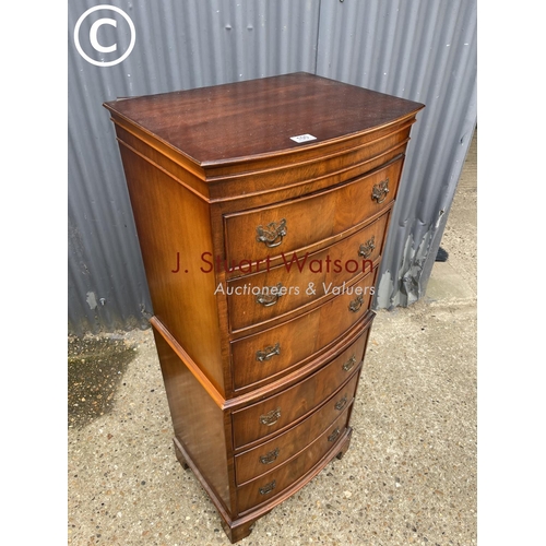 100 - A reproduction mahogany tallboy chest of six drawers with a bow front