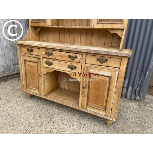 11 - A large antique pine dresser of South Wales Origin with glazed top(lacking one window) over four dra... 