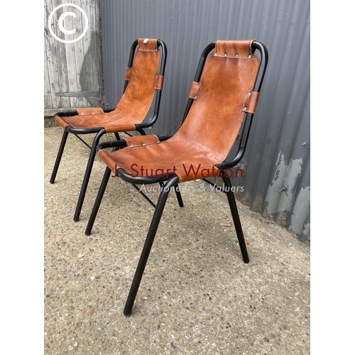 113 - A pair of metal framed stacking chairs with brown leather seats