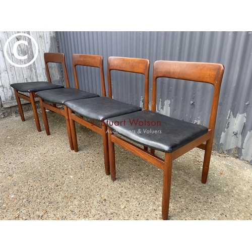 119 - A set of four danish style teak dining chairs with black vinyl seats